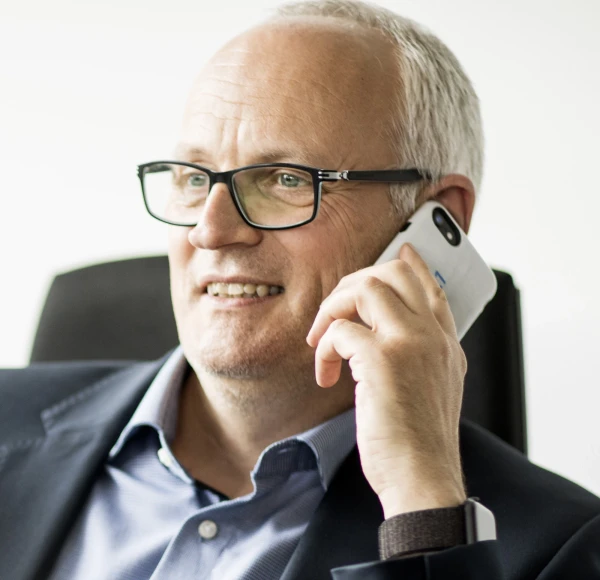 Bild von Claus Maisch, l&auml;chelnd mit Telefon am Ohr